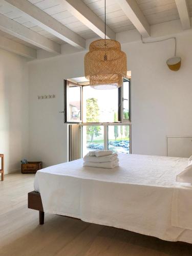 a bedroom with a white bed with a large window at CABANON urban apartments in Peschiera del Garda