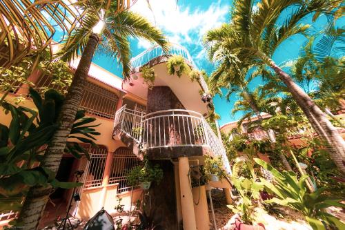 a building with a balcony and palm trees at Residence Tropical Garden in Boca Chica