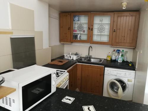 a kitchen with a white microwave and a sink at Budget Double Bedroom Near Glasgow City Centre and West End in Glasgow