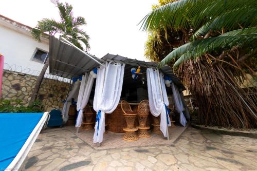 a patio with a umbrella and wicker chairs and a table at Residence Tropical Garden in Boca Chica