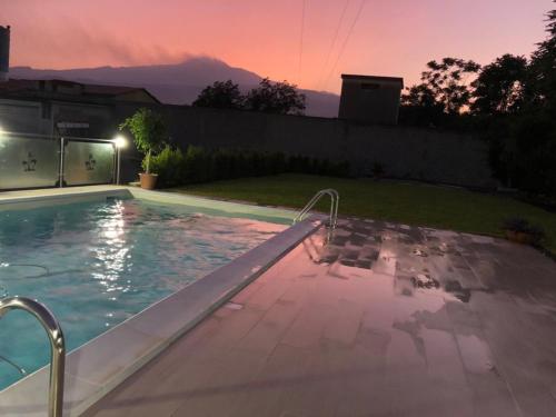 a swimming pool in a backyard at night at Veda elegant rooms in Fiumefreddo di Sicilia