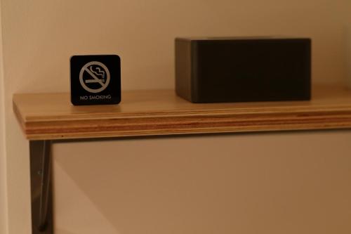 a no smoking sign sitting on a wooden shelf at Hotel Oriental Express Tokyo Kamata in Tokyo