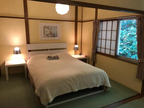 a bedroom with a large bed with two tables and a window at Naeba Ski Resort & Fuji Rock in Yuzawa