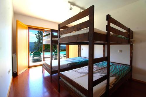 two bunk beds in a room with a balcony at Casa dos Cinco - Gerês in Terras de Bouro