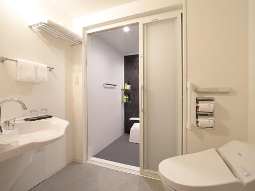 a bathroom with a shower and a toilet and a sink at Hotel Oriental Express Tokyo Kamata in Tokyo