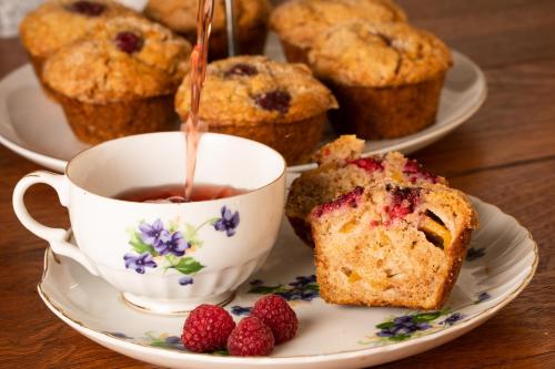 a cup of tea with a muffin and berries on a table at Rosemont Inn in Utica