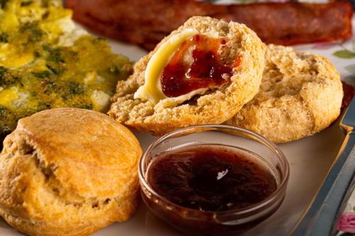 a plate of food with muffins and a dipping sauce at Rosemont Inn in Utica