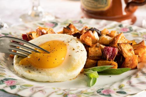 a plate of breakfast food with an egg and potatoes at Rosemont Inn in Utica