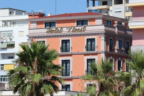 a building in the city with palm trees at Hotel Kloest in Durrës