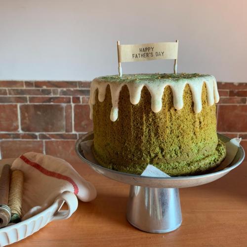 a cake on a cake stand with a happy birthday sign on it at Yamaharuka Historic House in Jinhu