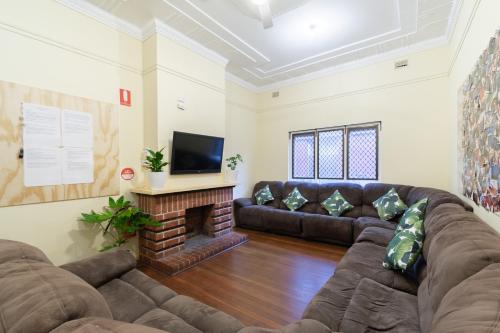a living room filled with furniture and a tv at myOZexp Aberdeen Lodge in Perth