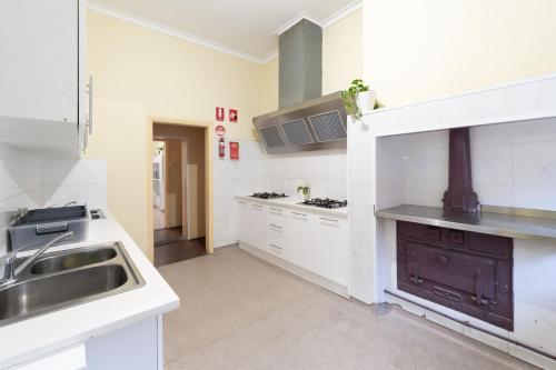 una grande cucina bianca con lavandino e piano cottura di myOZexp Aberdeen Lodge a Perth