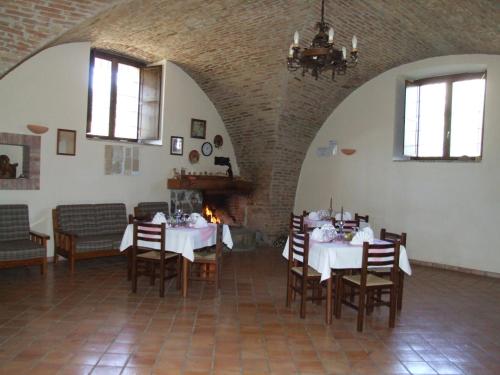 a dining room with tables and chairs and a fireplace at Antico Frantoio in Cerchiara di Calabria