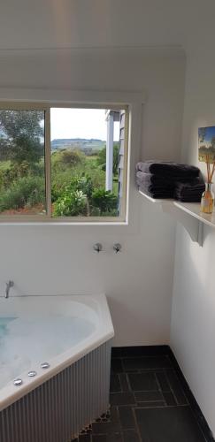 a white bathroom with a tub and a window at Mallavale Farm, Boat Harbour in Boat Harbour