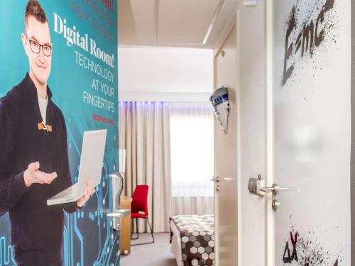 a man standing in a room with a laptop at Novotel Warszawa Airport in Warsaw