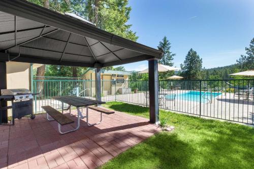 a patio with a picnic table and an umbrella at Timbers Motel in Bigfork