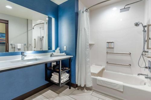 a bathroom with a sink and a tub and a shower at Cambria Hotel Davenport Quad Cities in Bettendorf