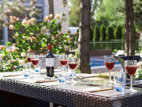 a table with wine glasses and a bottle of wine at Novotel Warszawa Airport in Warsaw
