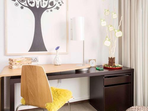 a desk with a chair and a table with a lamp at Novotel Warszawa Airport in Warsaw