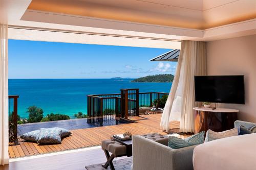 a living room with a view of the ocean at Raffles Seychelles in Baie Sainte Anne