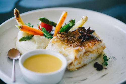 a plate of food with vegetables and a cup of soup at Raffles Seychelles in Baie Sainte Anne