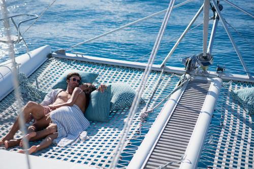 two people laying on a boat in the water at Raffles Seychelles in Baie Sainte Anne