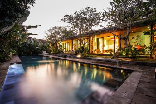 a swimming pool in front of a house at Surya Kembar Villas in Ubud