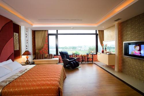 a hotel room with a bed and a flat screen tv at Chateau Motel & Spa in Kaohsiung