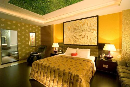 a hotel room with a bed and a couch at Chateau Motel & Spa in Kaohsiung