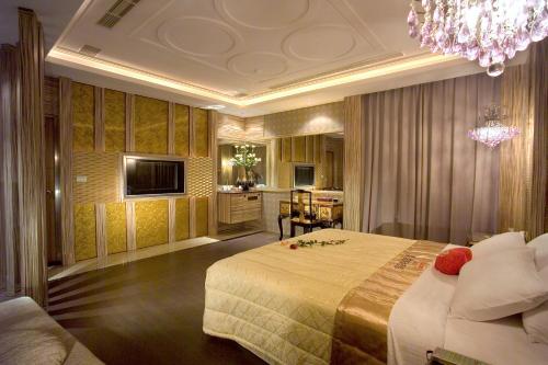 a bedroom with a large bed and a chandelier at Chateau Motel & Spa in Kaohsiung