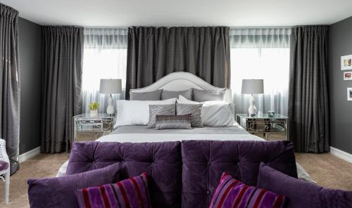a bedroom with a large bed with a purple couch at The Biskra House in Rancho Mirage
