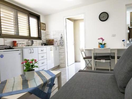 - une cuisine avec un canapé et une table dans une chambre dans l'établissement Carmela House, à Arad