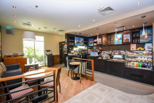 a bar in a restaurant with a man behind the counter at Premier Inn Dubai Investments Park in Dubai