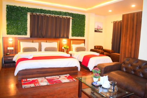 a hotel room with two beds and a couch at Amba Regency in Gangtok