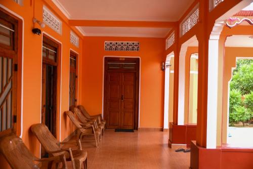 an orange hallway with chairs and a door at Tulip Guest Inn in Point Pedro