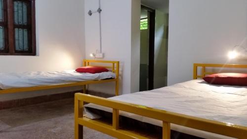 Habitación con 2 camas y espejo. en Beds & Boys Hostel, en Nagpur