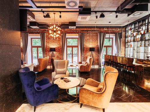a lobby with chairs and tables and a bar at Hotel Wawel Queen in Krakow
