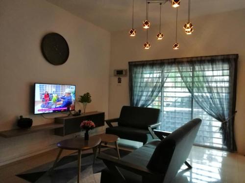a living room with a couch and a tv at alyaleesya homestay Teres in Brinchang