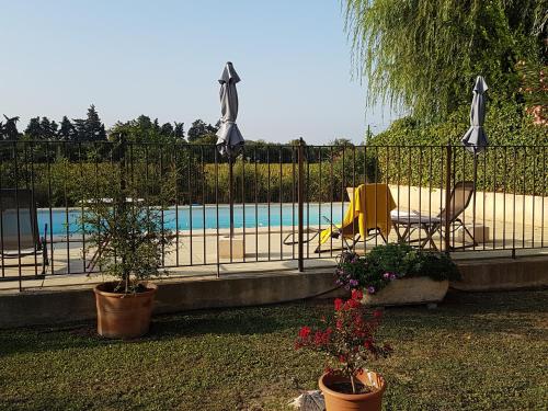 une clôture avec deux plantes en pot à côté d'une piscine dans l'établissement fleur de garance, au Thor