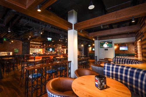 a restaurant with wooden tables and chairs and a bar at Premier Inn Dubai Al Jaddaf in Dubai