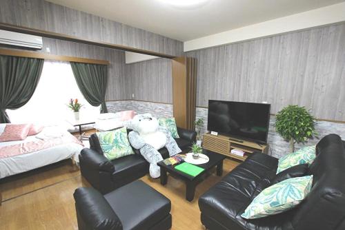 a living room with a teddy bear sitting on a table at LaForet inn 303  in Hiroshima