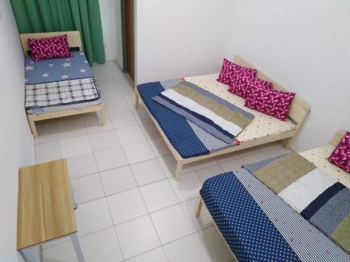 a room with two beds and a table and chairs at Jerantut Homestay 2 in Jerantut