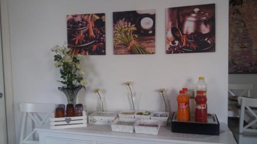 a white table with bottles and pictures on the wall at Venustas in Lampedusa