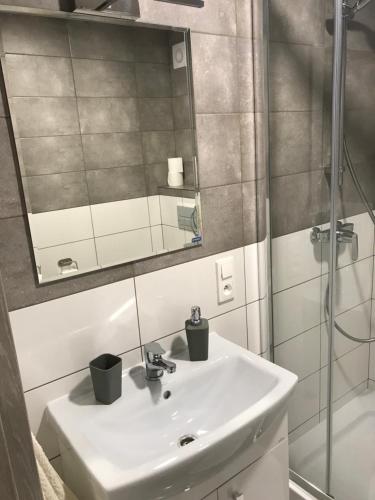 a bathroom with a sink and a mirror and a shower at Przytulisko na Mazurach in Ruciane-Nida