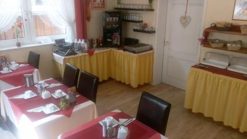 a restaurant with two tables with red and yellow table cloth at Arador-City Hotel in Bad Oeynhausen