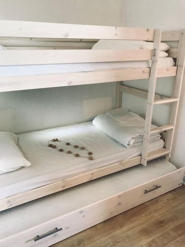 - un lit superposé blanc avec quelques oreillers dans l'établissement Charmant studio cabine COSY à 100 m des pistes, à Chamrousse