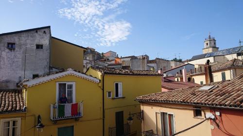 a group of buildings with a person on a balcony at Casa Vacanza PIAZZA APARTMENT 1 in SantʼAndrea di Conza