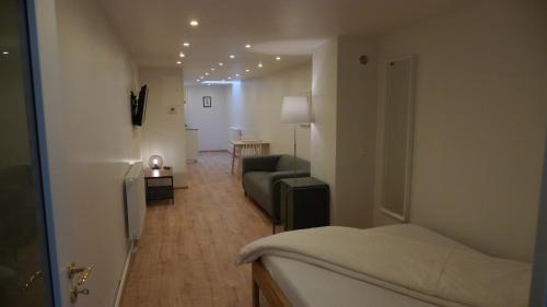 バーデン・バーデンにあるFerienwohnung im Baldreitのベッド1台付きの部屋、ソファ付きのリビングルームが備わります。