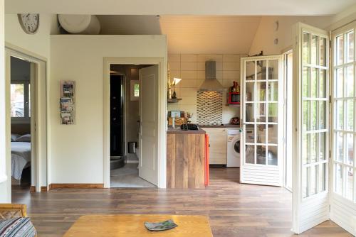 een keuken met witte muren en houten vloeren bij Gite L'Ane Qui Rit in Le Breuil