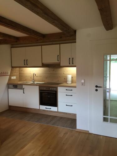 a kitchen with white cabinets and a sink at Schweizer Häusl in Bayerisch Eisenstein